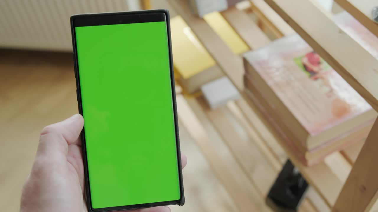 초록색 모의 화면을 가진 스마트폰을 사용하여 집에있는 사람의 pov 뷰, 버전 3