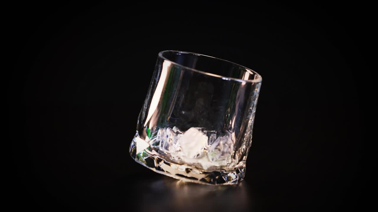 la mano deja caer cubos de hielo en un vaso