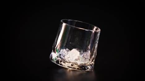 hand drops ice cubes into a glass