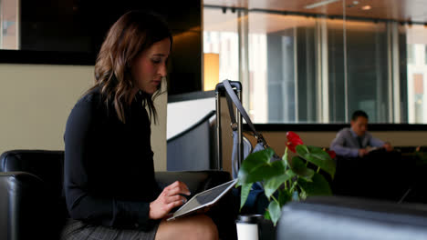 Vista-Lateral-De-Una-Hermosa-Mujer-De-Negocios-Caucásica-Usando-Una-Tableta-Digital-En-El-Lobby-De-Un-Hotel-4k