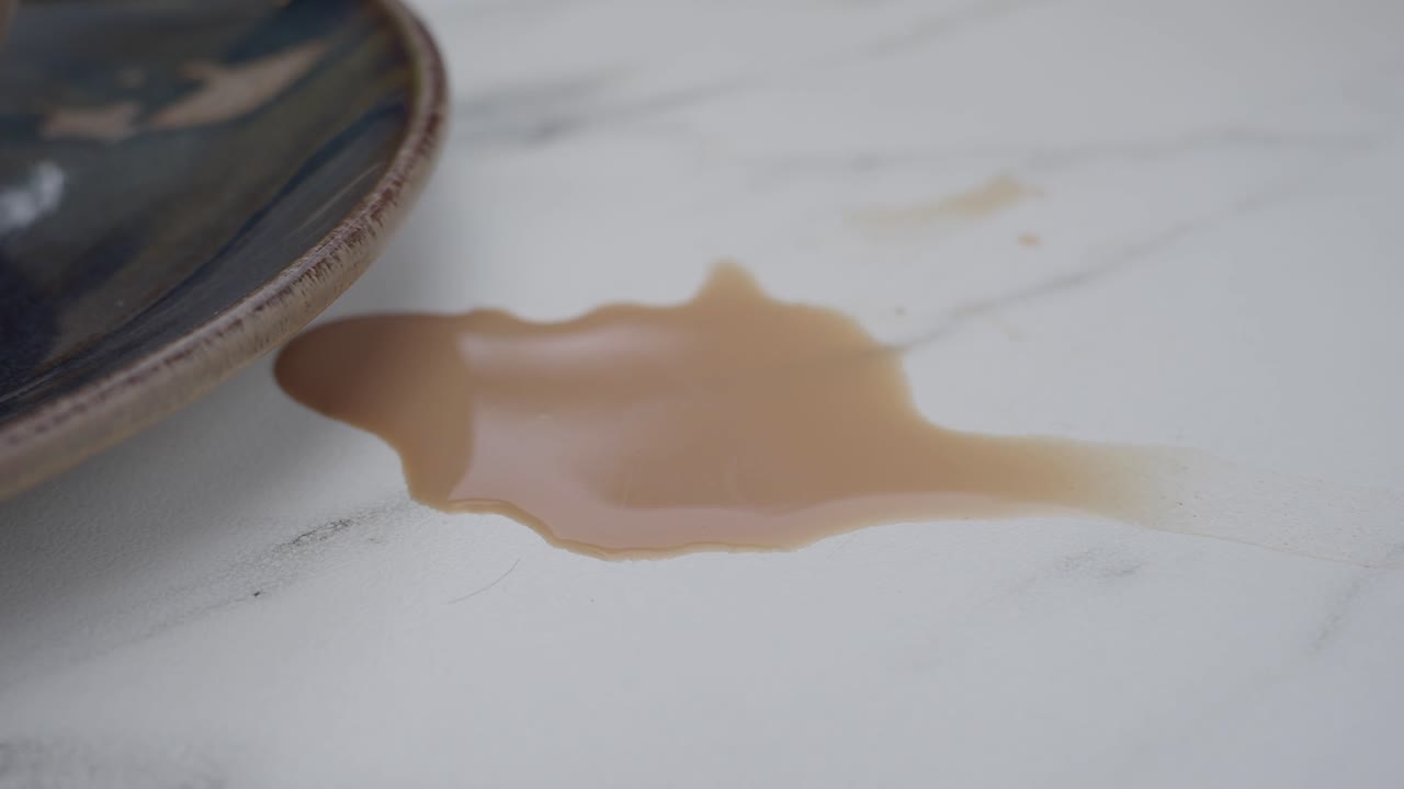 Close-up of a spilled coffee or tea on a white table