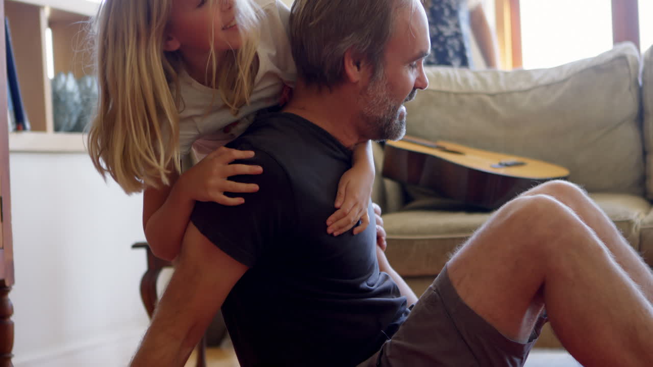 아버지와 딸이 거실 4k에서 즐거움을 즐기고 있습니다.