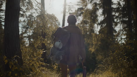 woman with backpack walking in forest