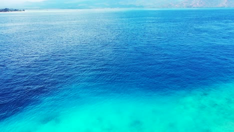 aerial of the beautiful blue waters waters and a scenic view of mountains on the horizon