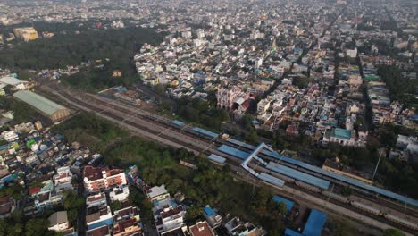 aerial drone shot of railway with train passing through the middle of the city