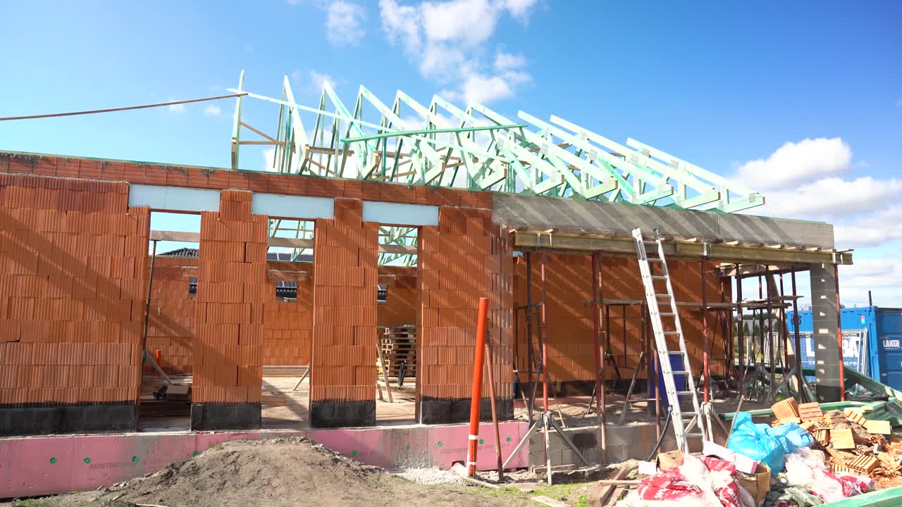 Exterior view of brick house under construction with impregnated timber roof trusses