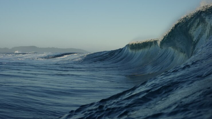 Ocean surface view of water catching green reflection from light to underwater vortex