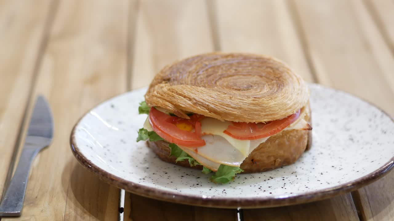 mano con un delicioso sándwich de croissant