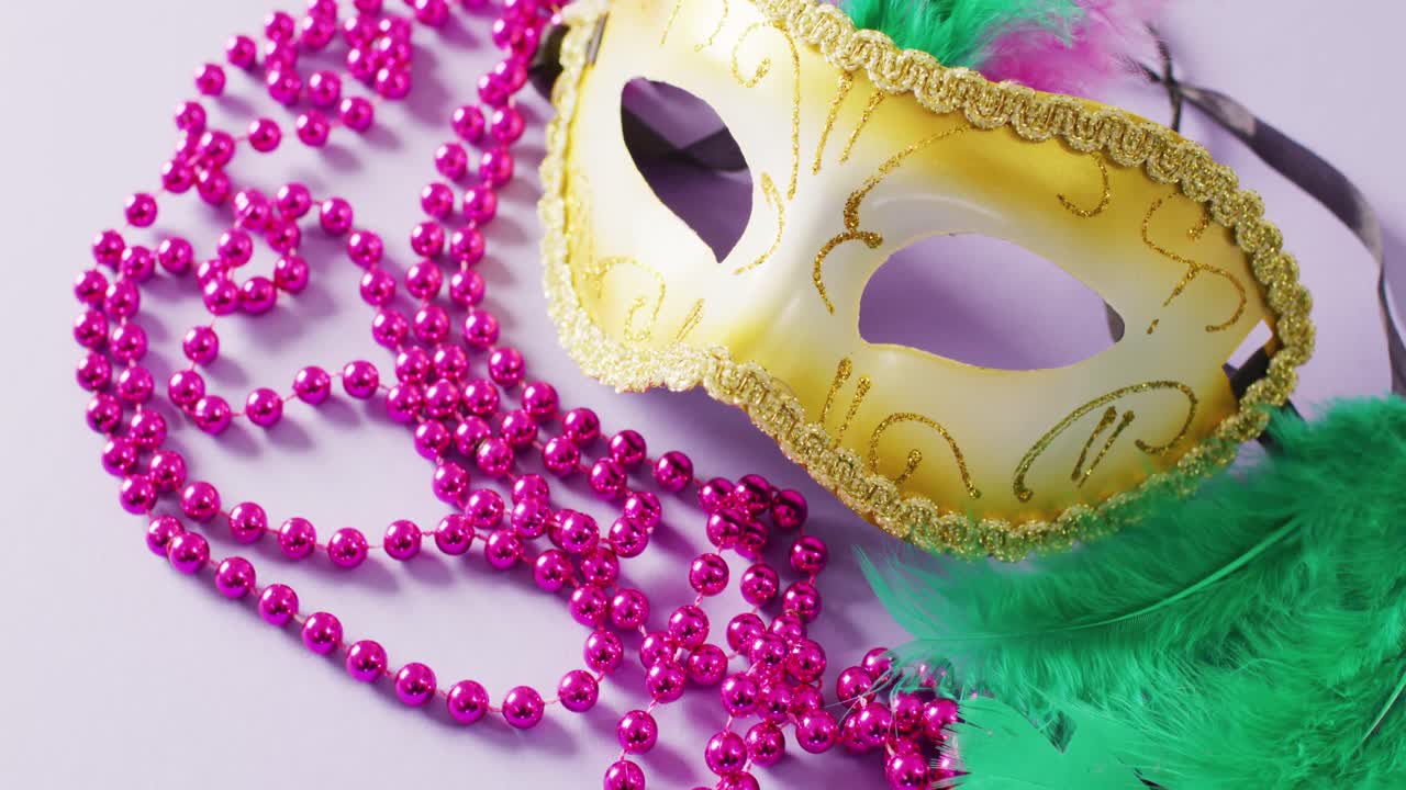 Video di maschera di carnevale con piume verdi e collane di Mardi Gras rosa