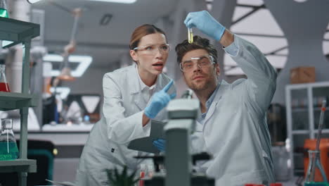 colegas de laboratorio comprobando muestras de medicamentos en la clínica de genética de cerca.