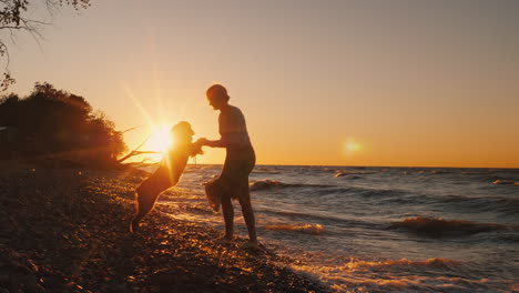 Silhouette-Of-A-Woman-Who-Plays-With-Her-Dog-Breed-Caucasian-Shepherd-At-Sunset