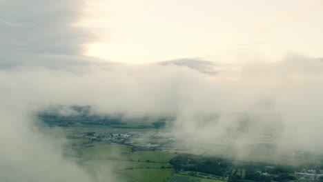 an aerial evening shot with the camera inside the rolling clouds, above a beautiful countryside | edinburgh | shot in 4k at 30 fps