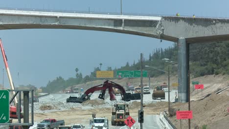 Excavadoras-Cavan-Cerca-De-Un-Tramo-Vacío-De-La-Autopista-405-En-Los-ángulos-Mientras-Los-Equipos-Derriban-Parte-De-Un-Puente