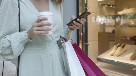 vista recortada de la mujer escribiendo en el teléfono inteligente