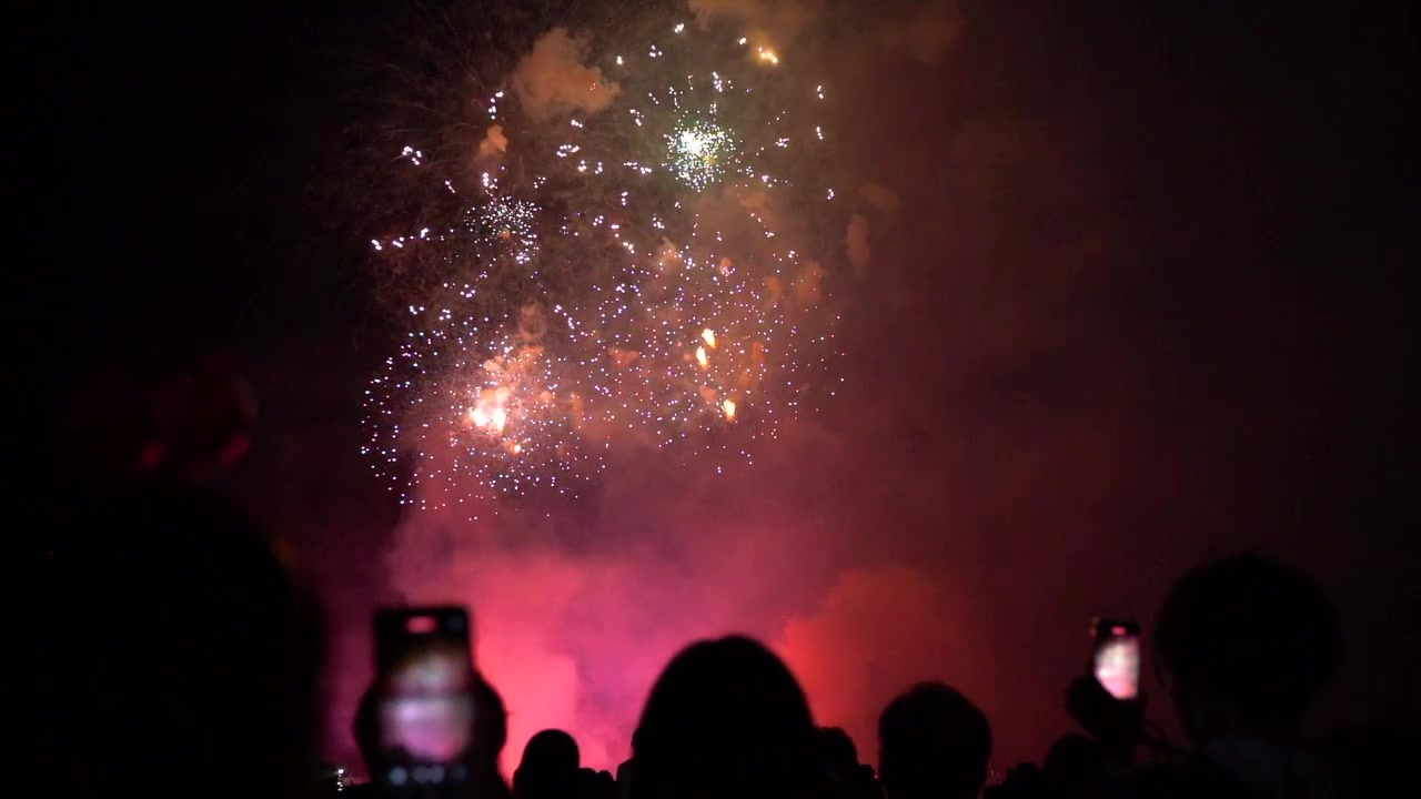 Cinematic fireworks scenery with people silhouettes watching