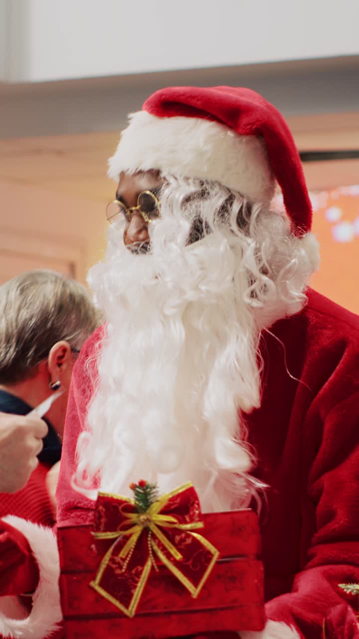 Vídeo vertical: casal entregando um bilhete de rifa para o Papai Noel