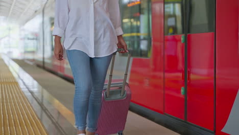 woman at train station with suitcase