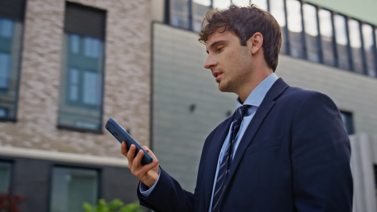 Excited winner looking cellphone on modern street closeup. Overjoyed businessman