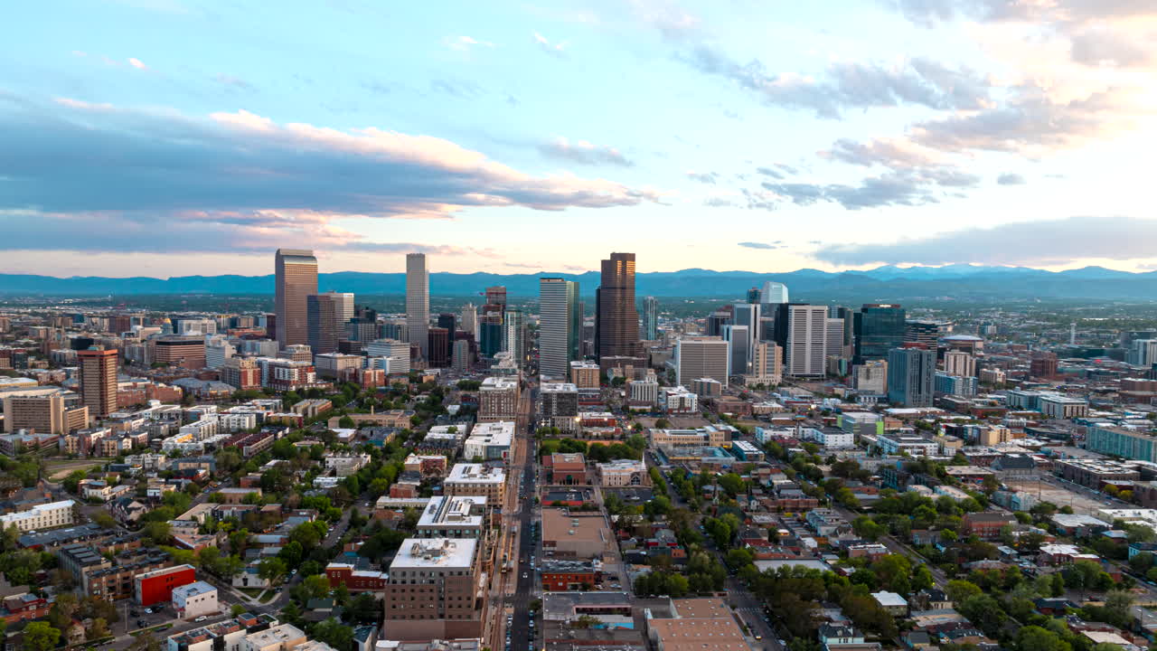 Arcing aerial hyperlapse view of Denver Mile High city skyline over Curtis Park