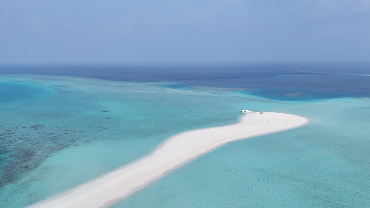 Riprese aeree con drone di un'isola con bancata di sabbia bianca in una laguna turchese, Maldive 4K