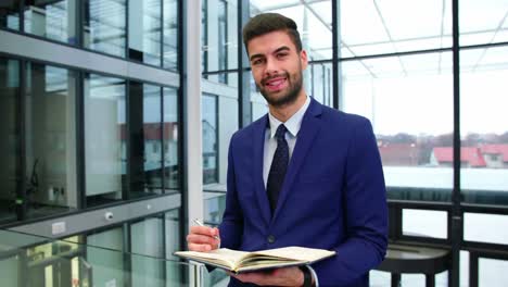 businessman writing in diary at office