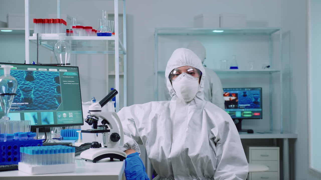 지친 화학자가 커버를 입고 카메라를 보고 있다