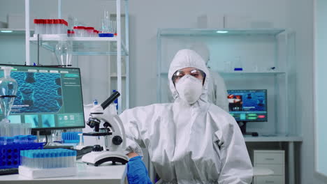 exhausted chemist looking at camera wearing coverall