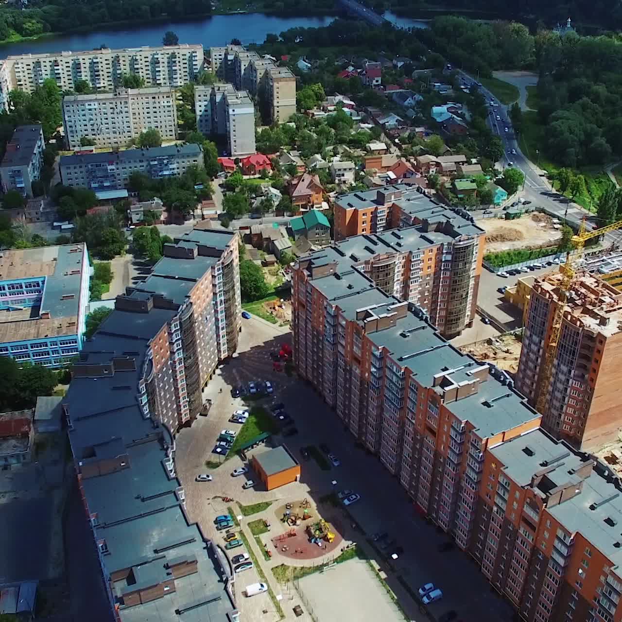 Modern industrial complex in the city. Development of high buildings. Construction site on the cityscape background. Aerial view.