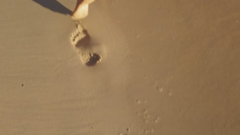 A-slow-motion-shot-of-woman´s-feet-leaving-footprints-on-the-sand-just-in-the-shore