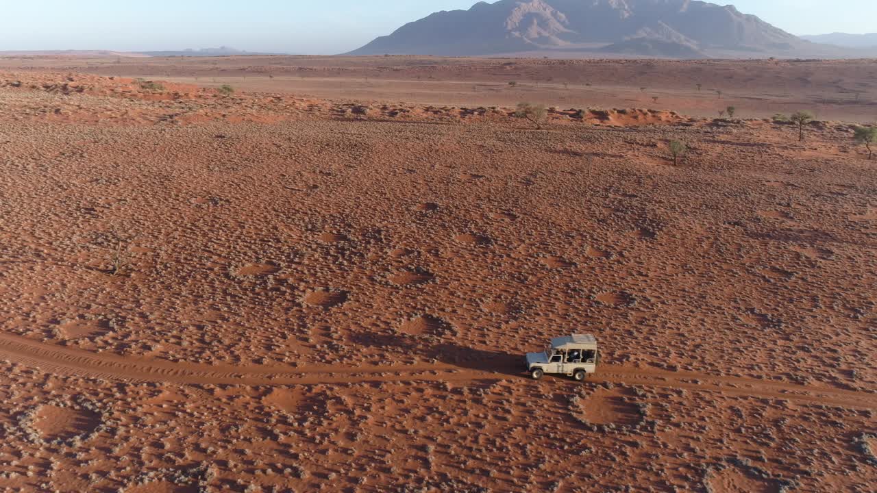 나미비아 의 유명 한 요정 서클 을 가로질러 운전 하는 사파리 차량 의 공중 사진