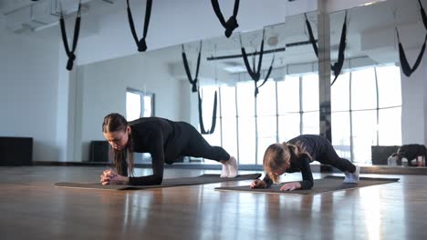 mother and daughter doing yoga in gym