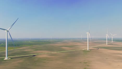 Turbinas-Eólicas-En-Línea,-Central-Eólica,-Texas-San-Roman,-Temprano-En-La-Mañana,-Cielo-Brumoso,-Transición-Energética,-Vuelo-Aéreo-Con-Drones