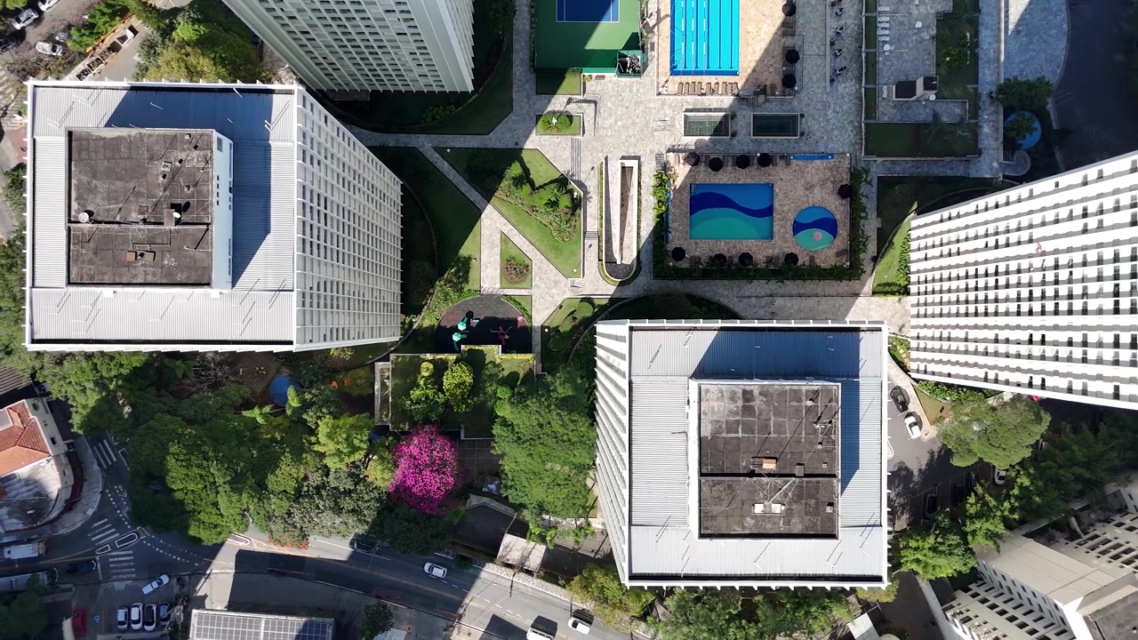 Tomada Aérea Lateral de Drone Mostrando Edifícios Residenciais de Luxo com Piscinas e Quadras de Tênis ao Lado de um Complexo Residencial Modesto, Perto do Parque Villa-Lobos em São Paulo