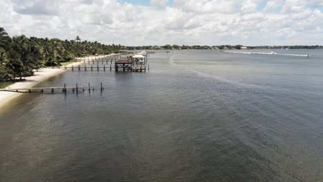 aerial view of docks along the coastline in south florida, palm trees blowing in the breeze