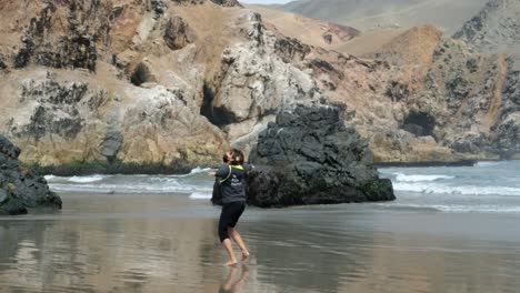 happy positive woman on the beach with face mask dancing in circles