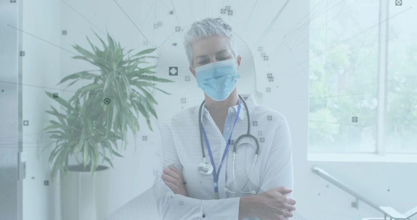 Dokter senior berjalan di lorong klinik mengenakan masker dan stetoskop menunjukkan penanda pengenalan wajah