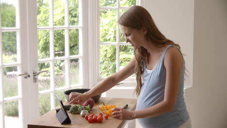 pregnant woman follows recipe on digital tablet shot on r3d