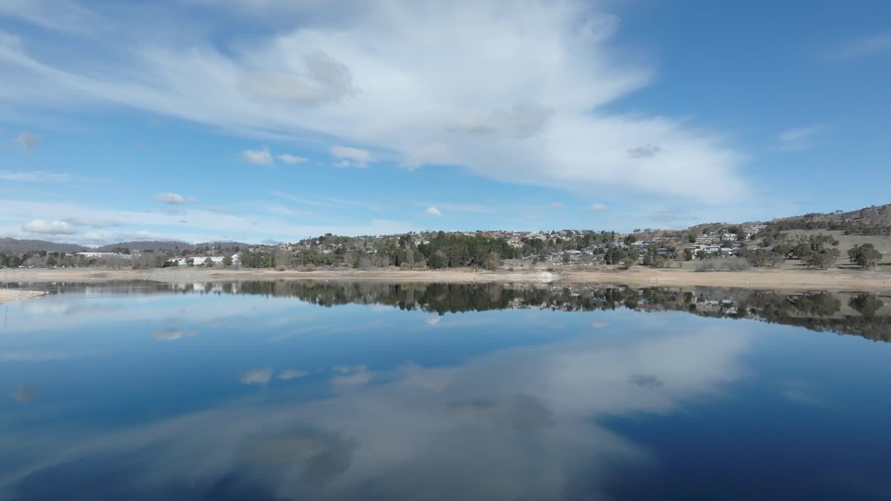 Drone flying low backwards over Lake Jindabyne, NSW, Australia