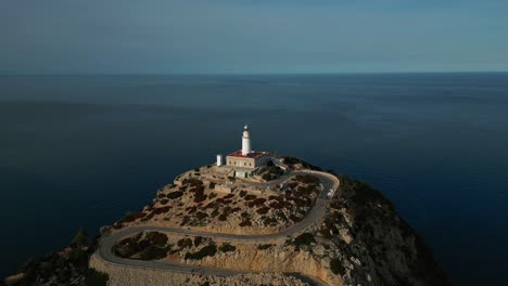 el icónico faro de cap de formentor con espectaculares acantilados, montañas y formaciones rocosas al atardecer