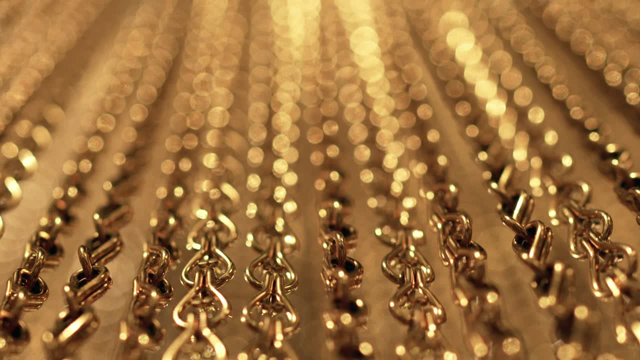 긴 금 사슬의 느리고 부드러운 움직임, 균일한 스, 휴식을 위한 금색 배경, 명상, 휴식, 진정시키기 위한 질감, 반이는 빛, 아래에서 위로 보이는 광경, 흐릿한 빛.