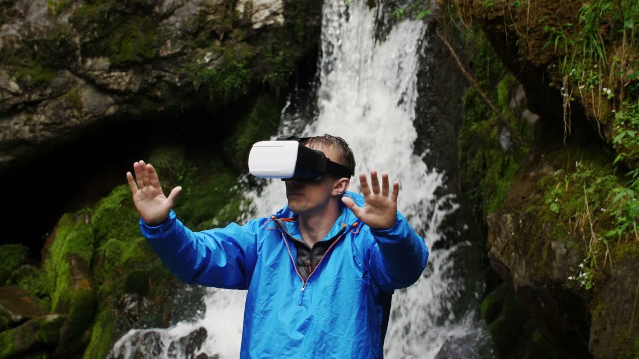Man Wearing VR Headset by Waterfall