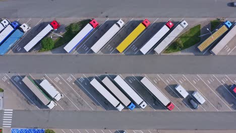 Highway-parking-with-a-lot-of-trucks-and-trailers-rest-area-for-truckers---aerial-ascending-shot