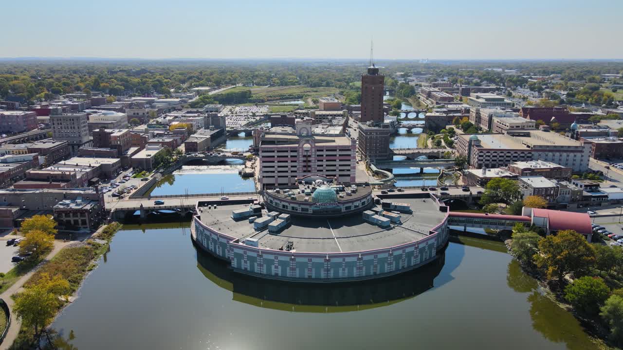 Drone footage capturing downtown Aurora, IL, a Chicago suburb in the Chicagoland area, near the river, buildings, and the Metra train line. Crane Down Right Day S