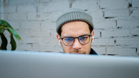 un hombre con un sombrero de moda y gafas está buscando información en internet. primer plano