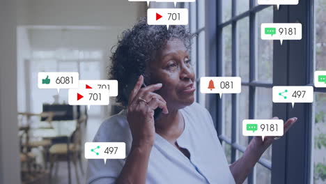 Animation-Von-Social-Media-Benachrichtigungen-über-Eine-Frau,-Die-Am-Fenster-Telefoniert