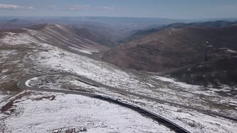 Luftaufnahmen-Der-Verschneiten-Landschaft-In-Lesotho,-Afrika---Schneefall-In-Afrika-Autofahren-Auf-Straßen-In-Verschneiter-Landschaft