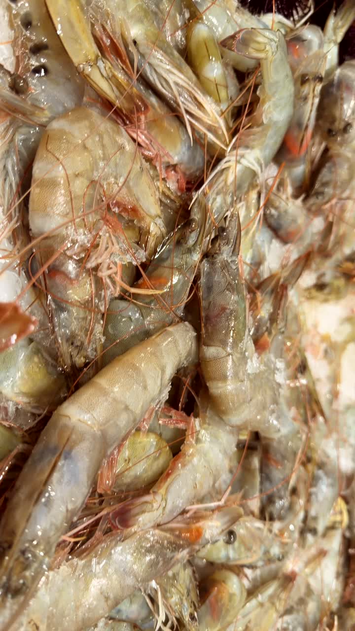 Primo piano di gamberi freschi e crudi su ghiaccio in una pescheria