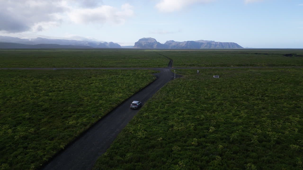 Car on remote Iceland road, scenic landscape, sense of exploration