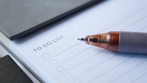 lista de tareas en el cuaderno con suministros de oficina en el escritorio