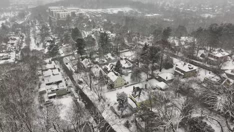 wooded neighborhoods stretch across worcester, massachusetts. houses cluster around winding streets. drifting above quiet suburbs, aerial.